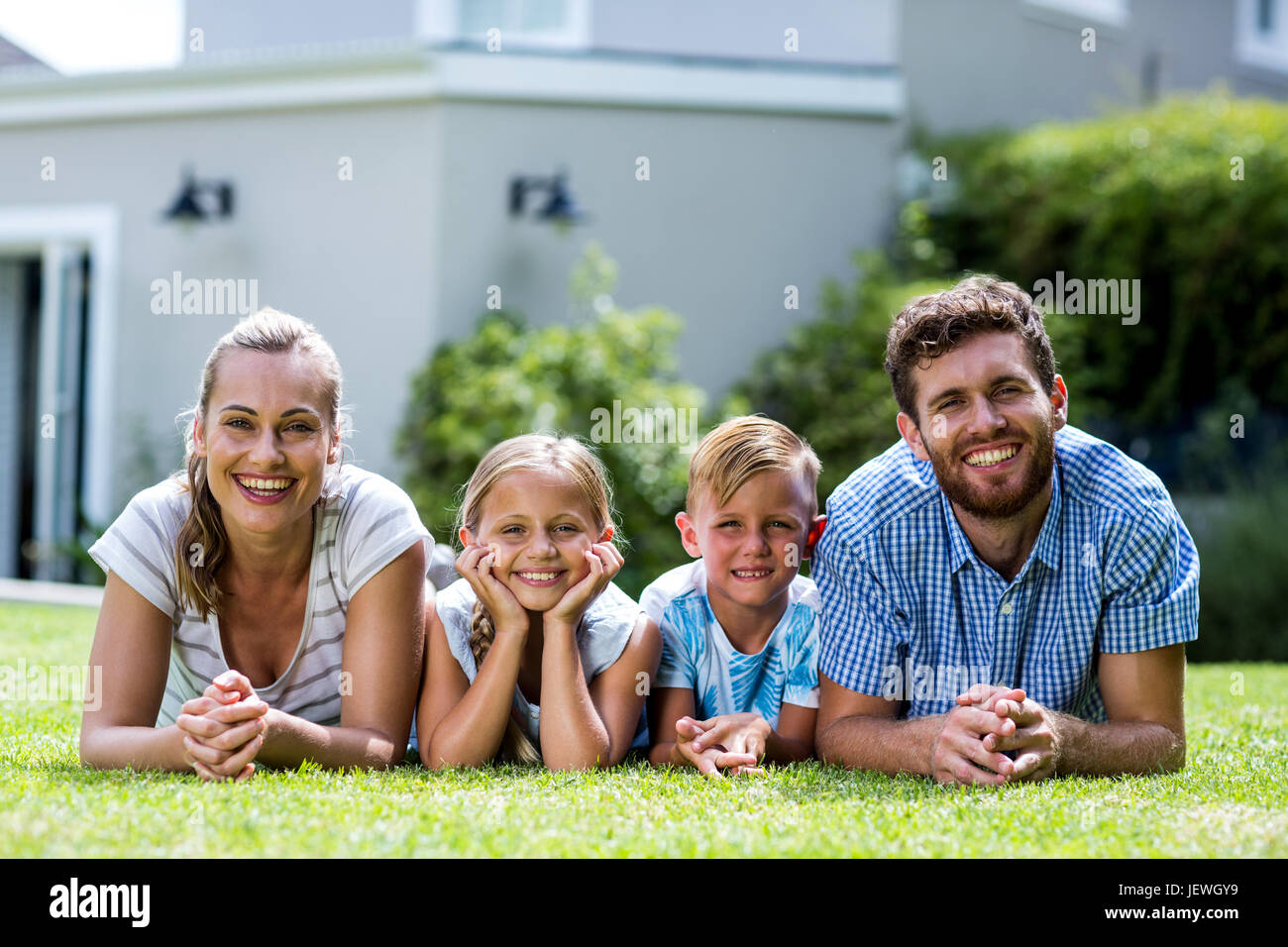 Front view of happy family lying in yard Stock Photo - Alamy