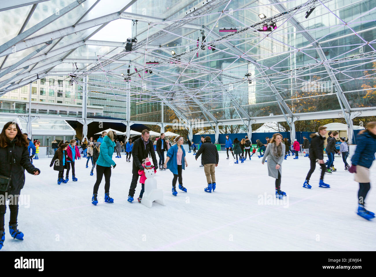 People ice skating on an ice rink in Canary Wharf, London, UK Stock Photo