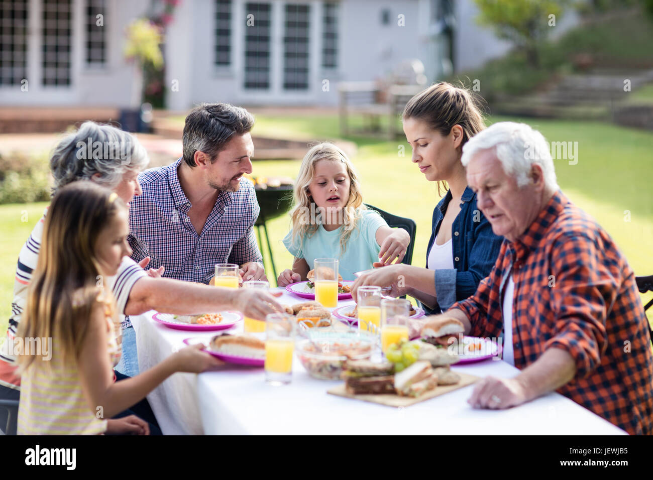 Happy family having lunch in the garden Stock Photo - Alamy