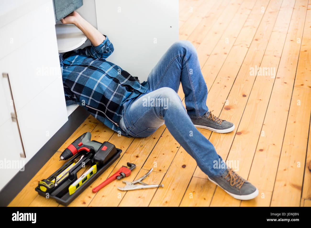 Man fixing kitchen sink Stock Photo - Alamy