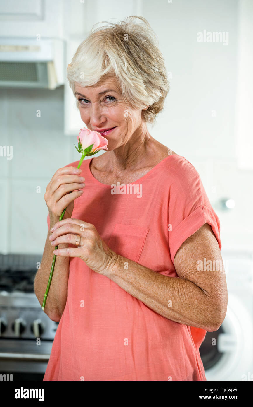 Portrait of smiling woman smelling rose Stock Photo - Alamy