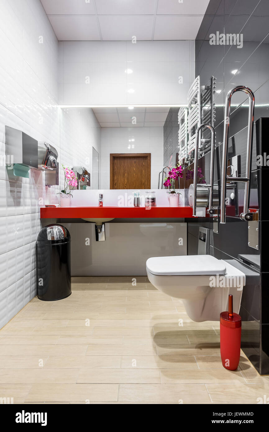 Black and white modern bathroom with toilet, red countertop and safety grab bars Stock Photo Alamy