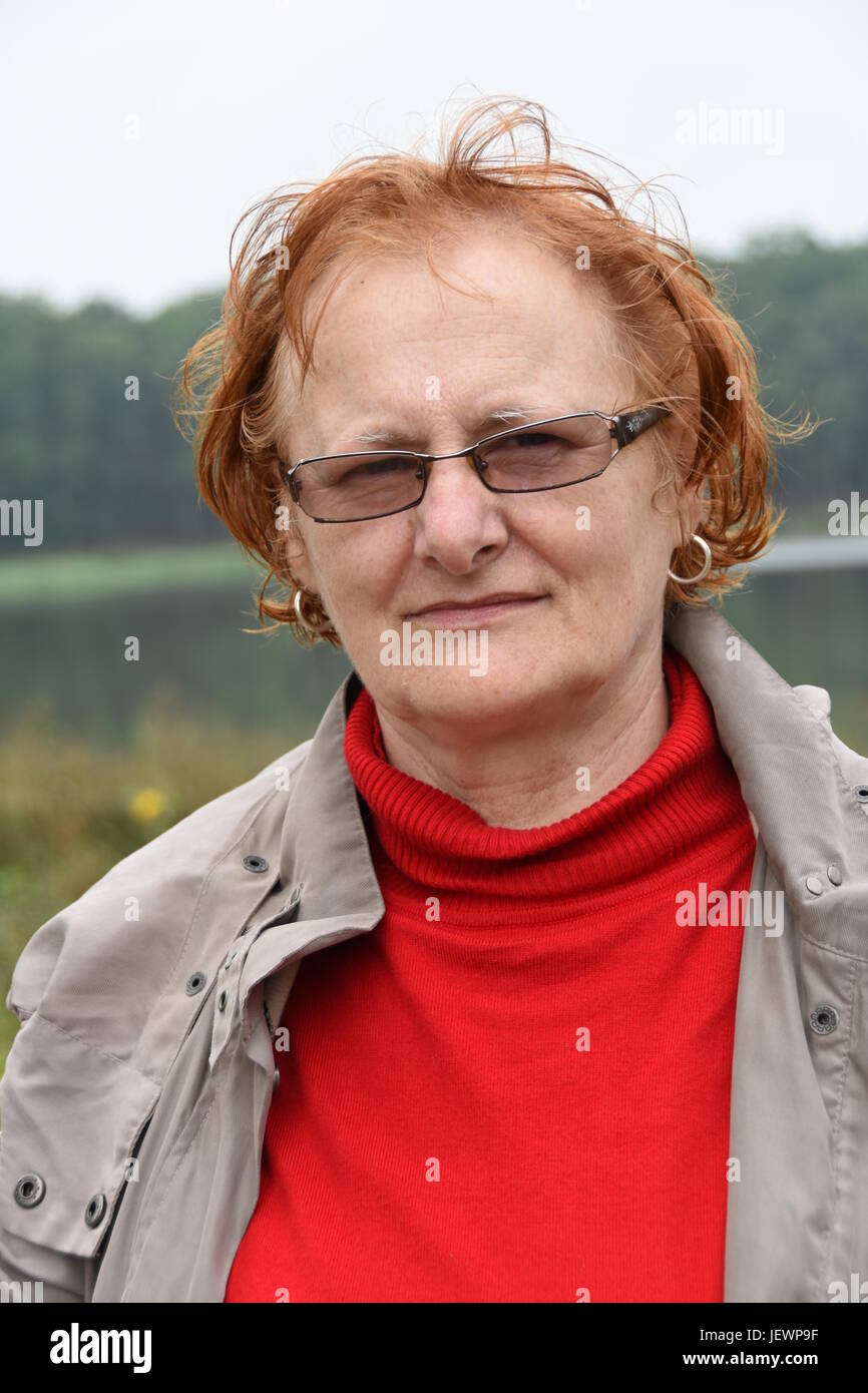 Older, red-haired woman with glasses Stock Photo - Alamy