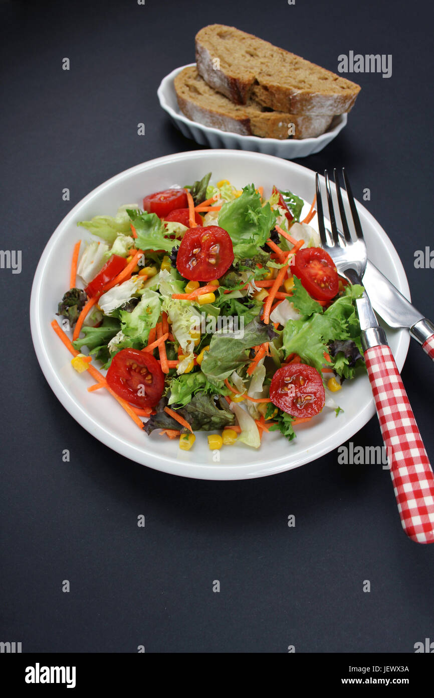 Gemischter Salat mit Roggenbrot und Besteck Stock Photo