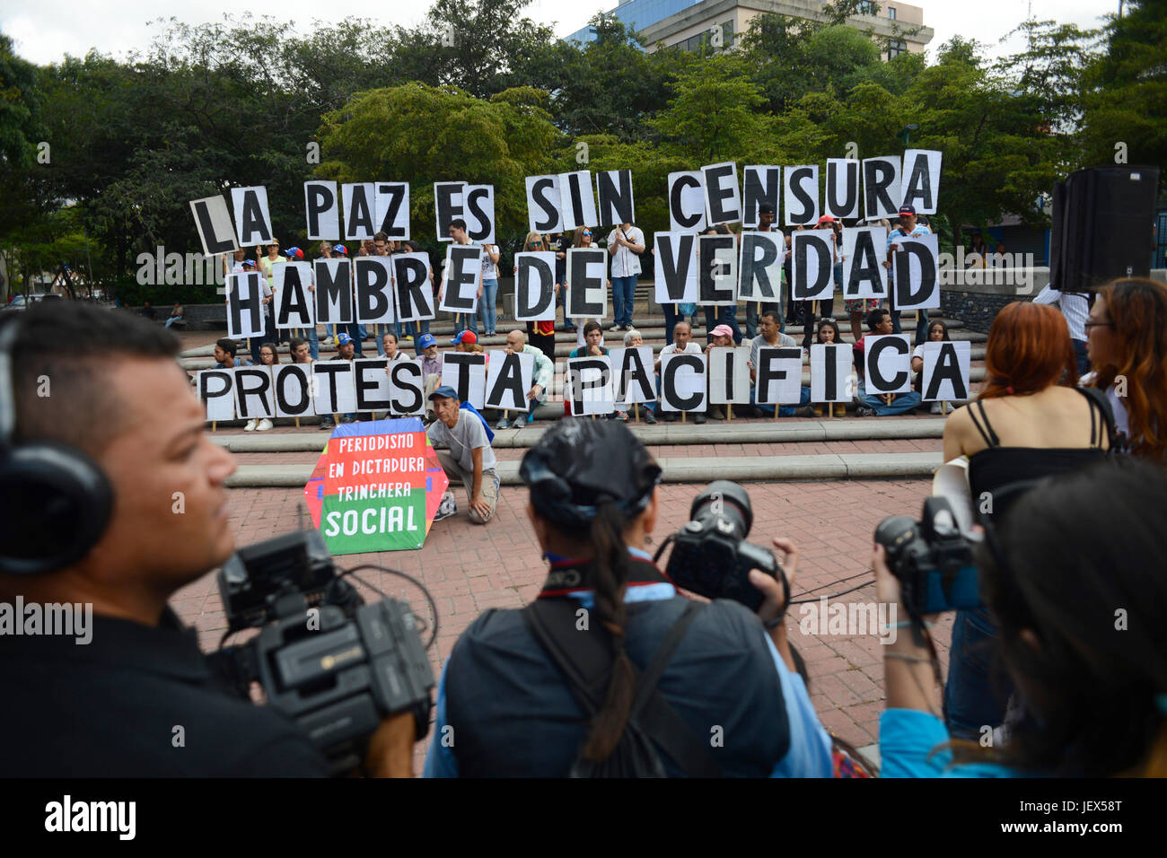 Caracas, Venezuela. 27th June, 2017. Protestors hold up signs saying 'La paz es sin censura' (lit. Freedom has no censorship), 'Hambre de verdad' (lit. hunger for truth) and 'Protesta pacifica' (lit. peaceful protest) at a protest march during the Day of the Journalist in Caracas, Venezuela, 27 June 2017. The demonstration is aimed against the socialist government of President Maduro. Numerous people have been taking daily to the streets for months. During said marches more than 70 people have lost their lives. Photo: Manaure Quintero/dpa/Alamy Live News Stock Photo