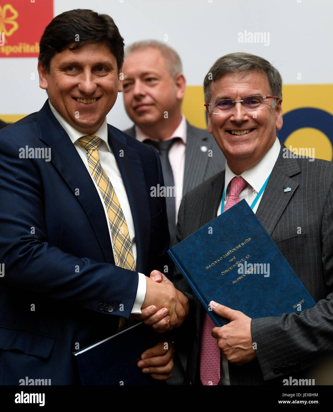 Prague, Czech Republic. 28th June, 2017. CEO of CSOB bank John Hollows (right), CEO of Czech Post Martin Elkan (left) and Interior Minister Milan Chovanec (back) attend the sign a contract on co-operation in banking and insurance services between Czech Post and CSOB in Prague, Czech Republic, on June 28, 2017. Credit: Michal Krumphanzl/CTK Photo/Alamy Live News Stock Photo