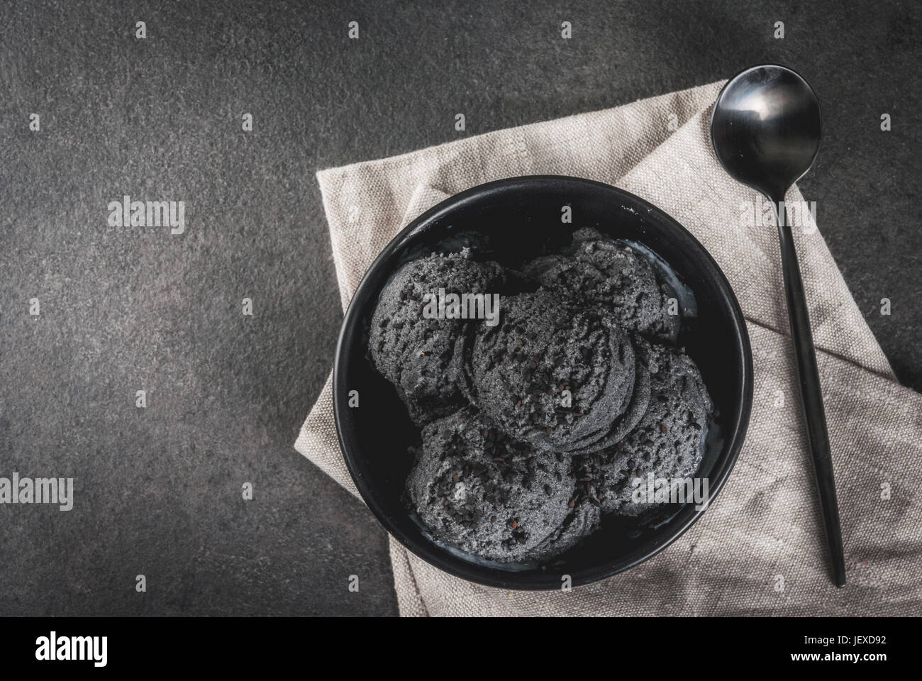 Trendy food. Black ice cream with black sesame, in a black bowl on a ...