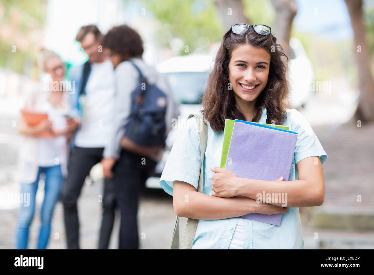 Portrait of young woman holding books Stock Photo - Alamy