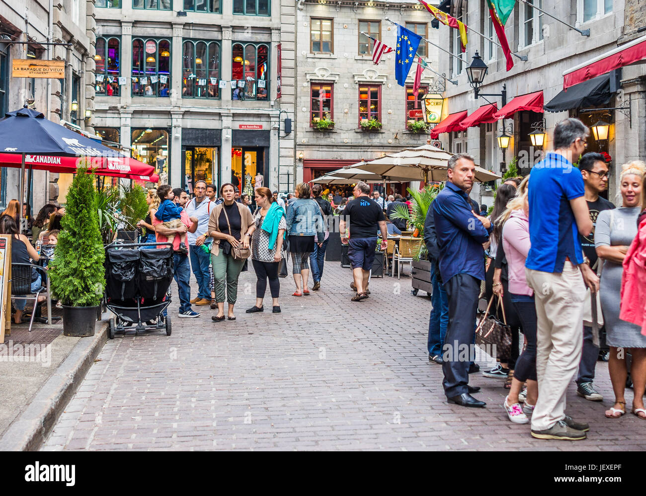 Montreal, Canada - May 27, 2017: Old town area with people walking up street in evening outside restaurants in Quebec region city Stock Photo