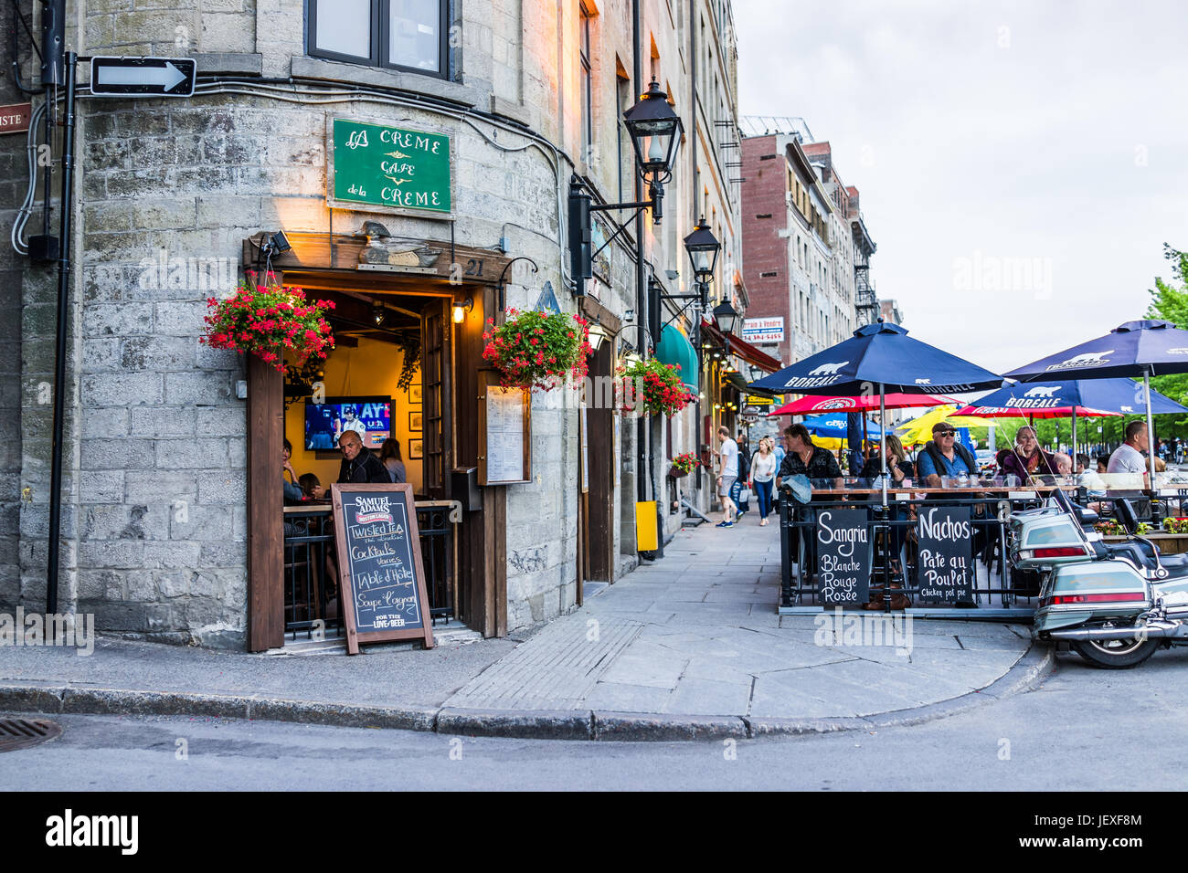 Montreal, Canada - May 27, 2017: Old town area with people sitting by street in evening outside restaurant called La Creme de la Creme in Quebec regio Stock Photo