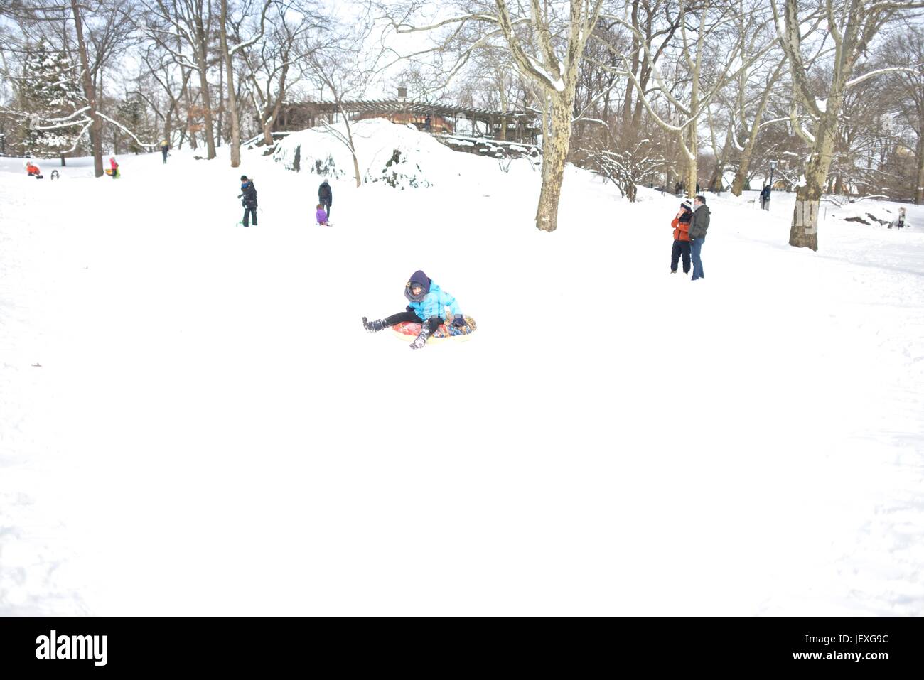 Sledding down a slope in Central Park in the aftermath of winter storm Juno. Stock Photo