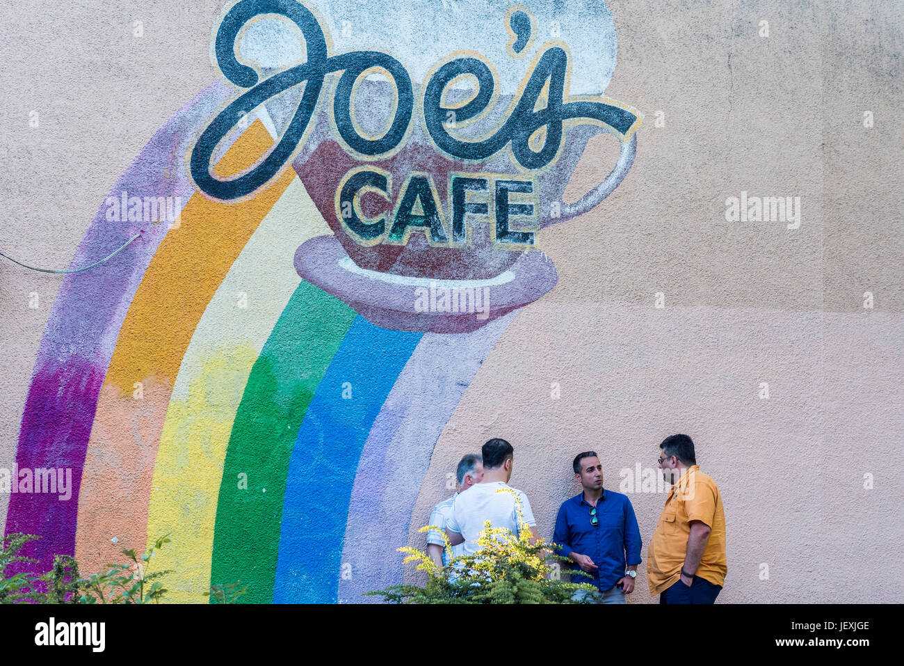 Italian guys chatting outside Joes Cafe, Commercial Drive neighbourhood, Vancouver, British Columbia, Canada. Stock Photo
