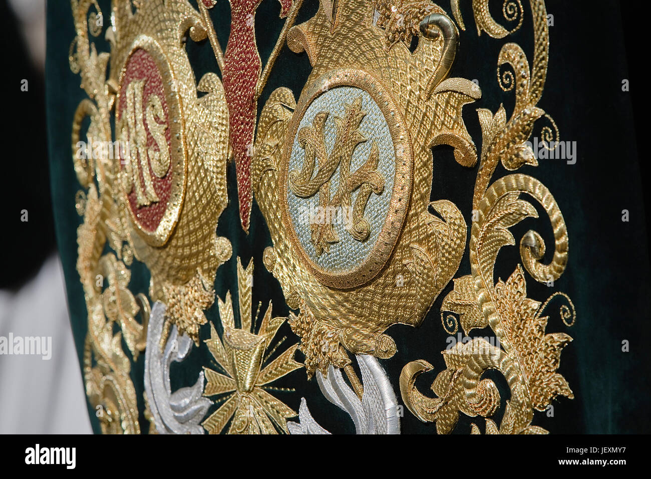 Embroidery thread of gold on green velvet with the acronym for Christ