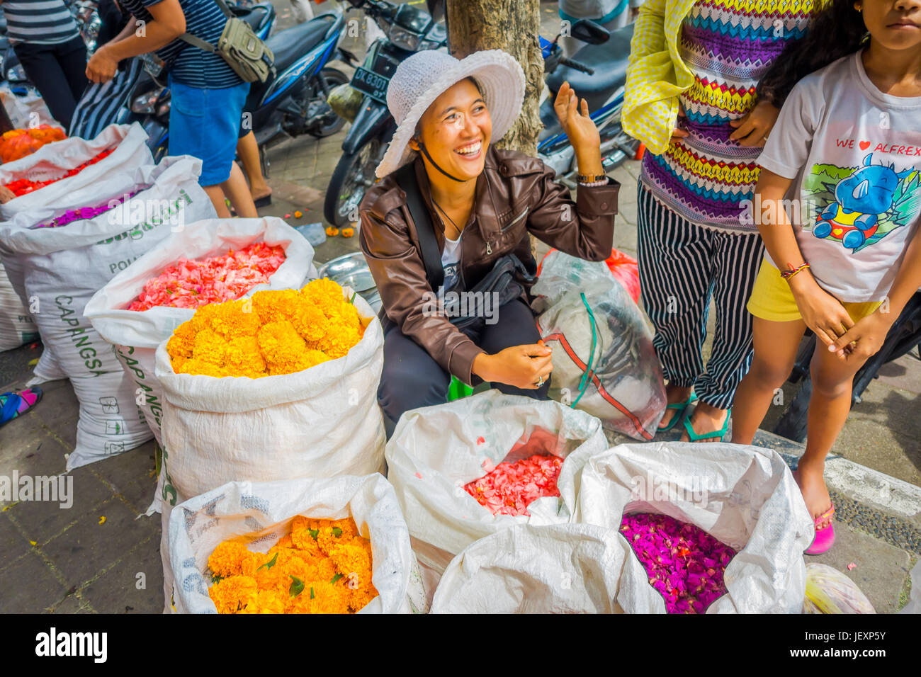 BALI, INDONESIA - MARCH 08, 2017: Unidentified people in outdoors Bali flower market. Flowers are used daily by Balinese Hindus as symbolic offerings  Stock Photo