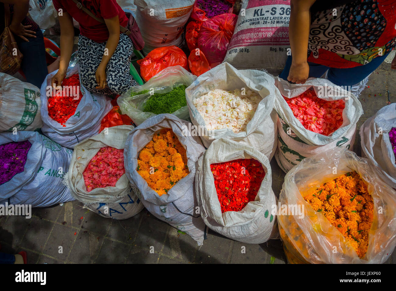 Outdoor Bali flower market. Flowers are used daily by Balinese Hindus as symbolic offerings at temples, inside of colorful baskets. Stock Photo