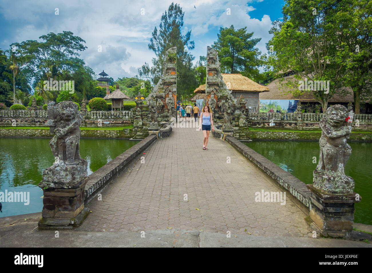 BALI, INDONESIA - MARCH 08, 2017: Unidentified woman walking inside of the temple of Mengwi Empire located in Mengwi, Badung regency that is famous pl Stock Photo