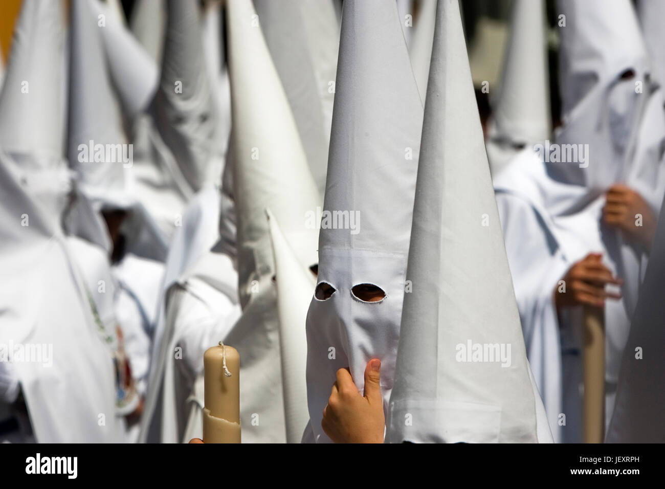 Detail penitent white holding a candle during Holy Week, Spain Stock Photo