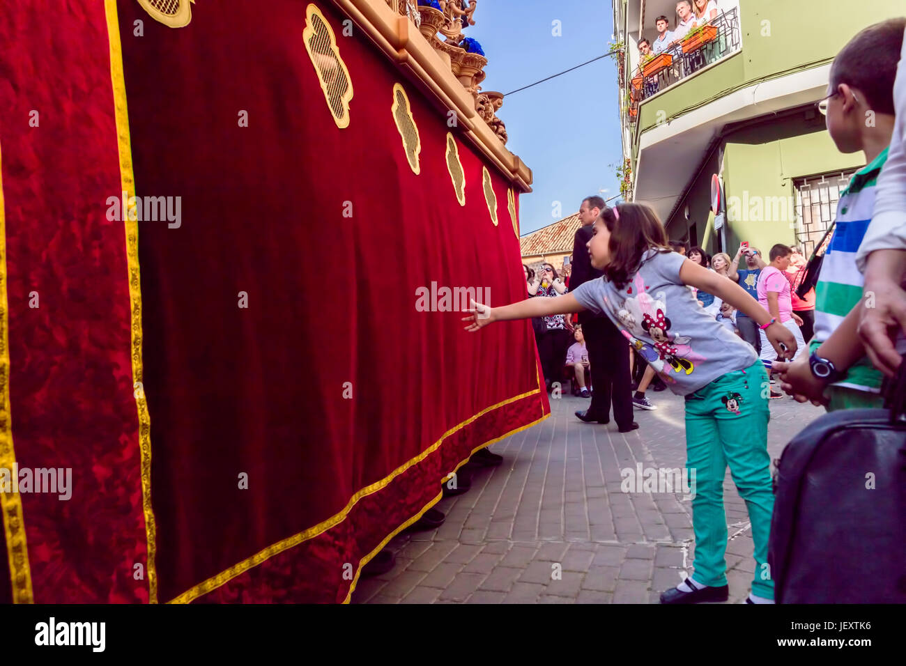 Linares, Jaen province, SPAIN - March 17, 2014: Girl tries to touch the skirt of the throne to have good luck, popular tradition in Andalusia, Easter  Stock Photo
