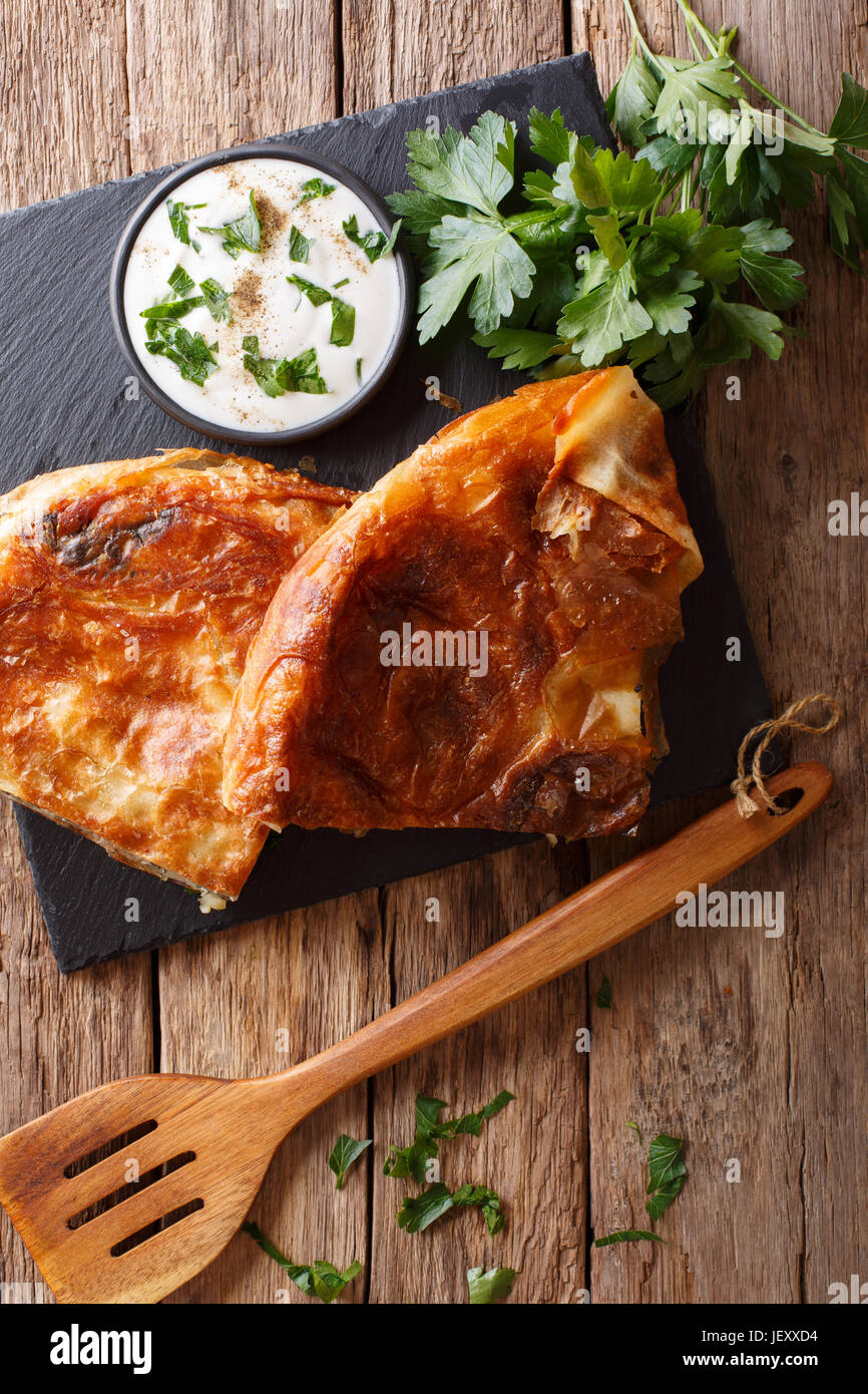 Balkan food: burek with spinach and cheese close-up on the table. Vertical view from above Stock Photo