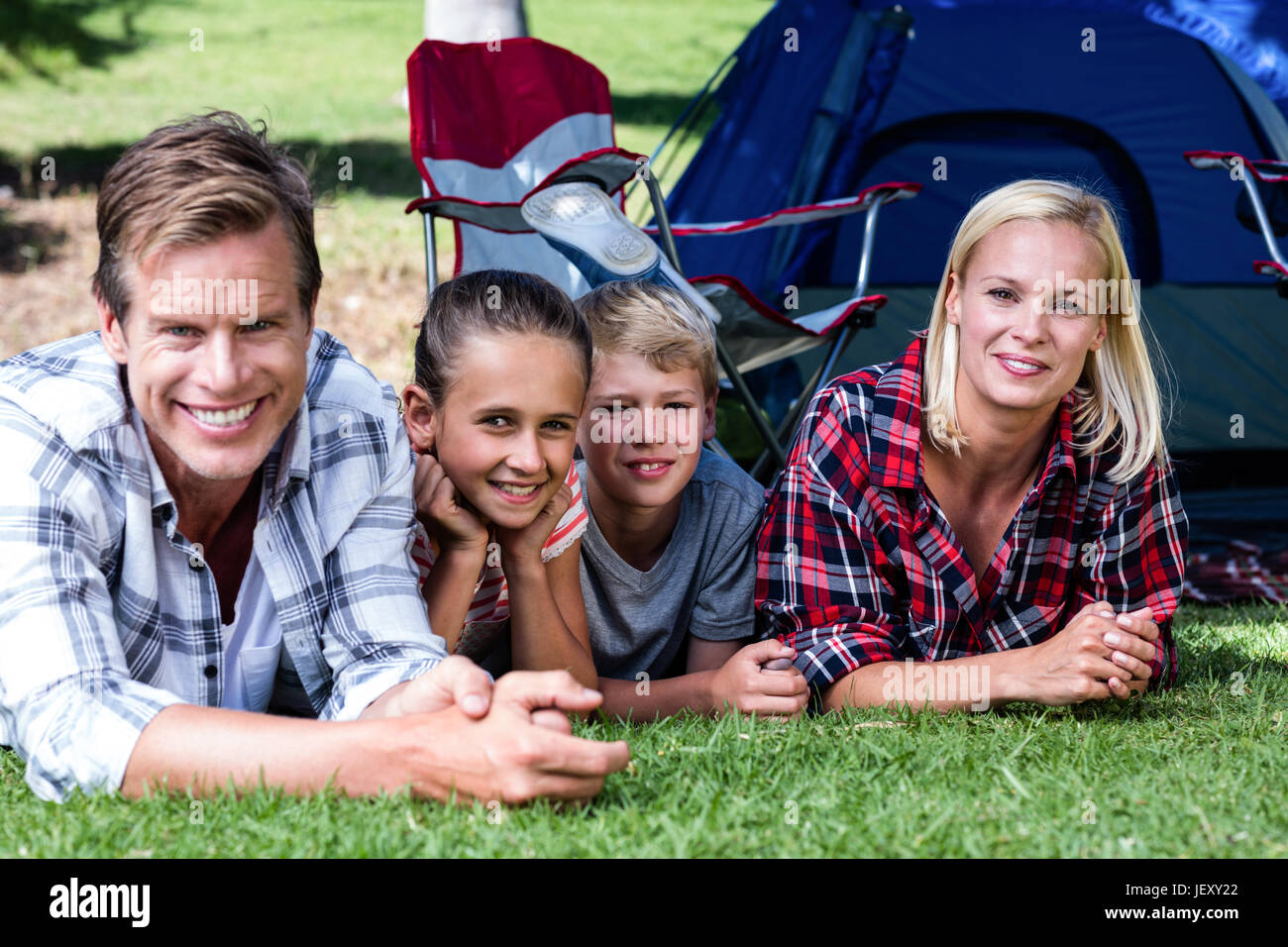 Portrait of happy family lying on grass Stock Photo - Alamy