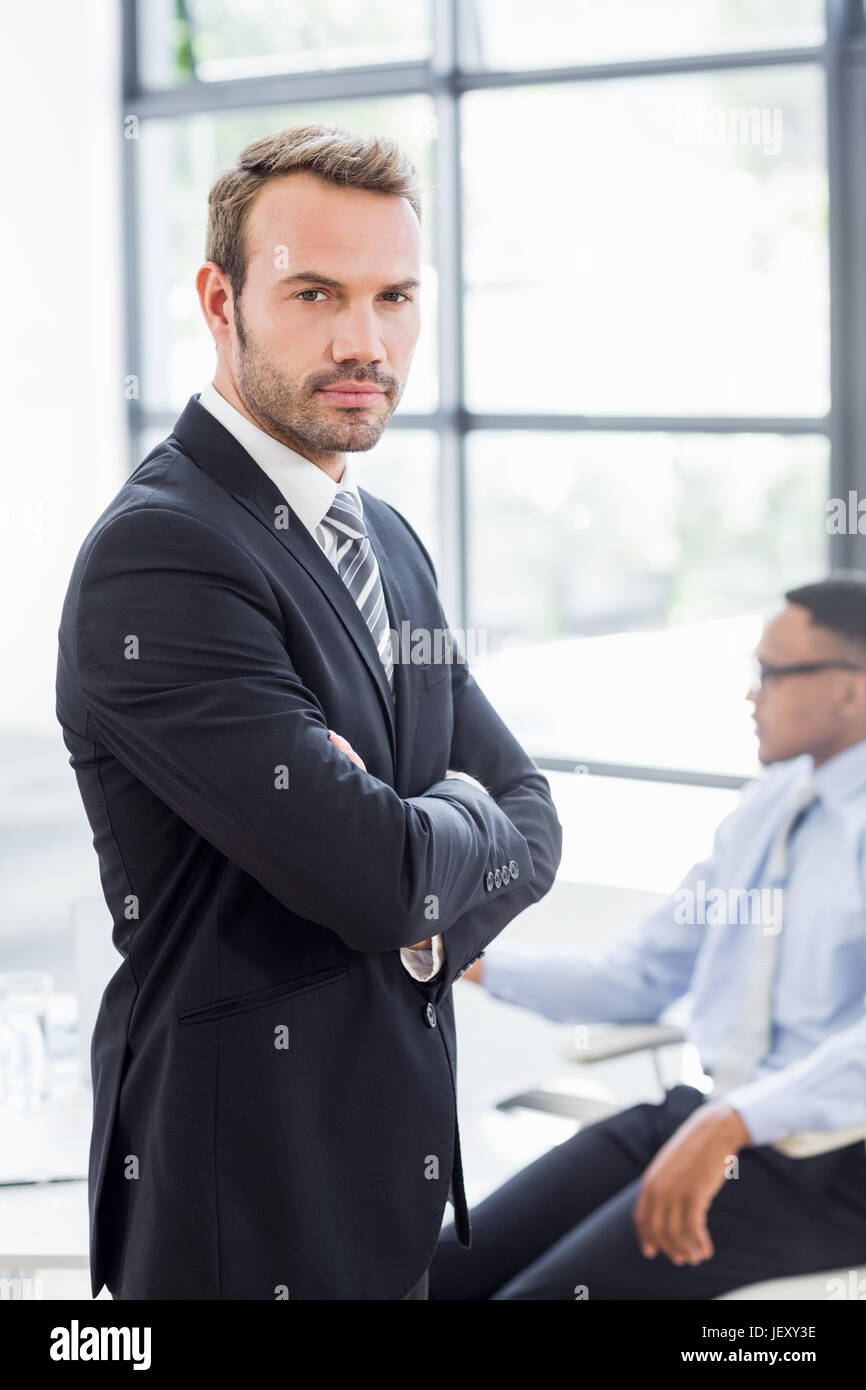 Happy businessman standing with arms crossed Stock Photo - Alamy
