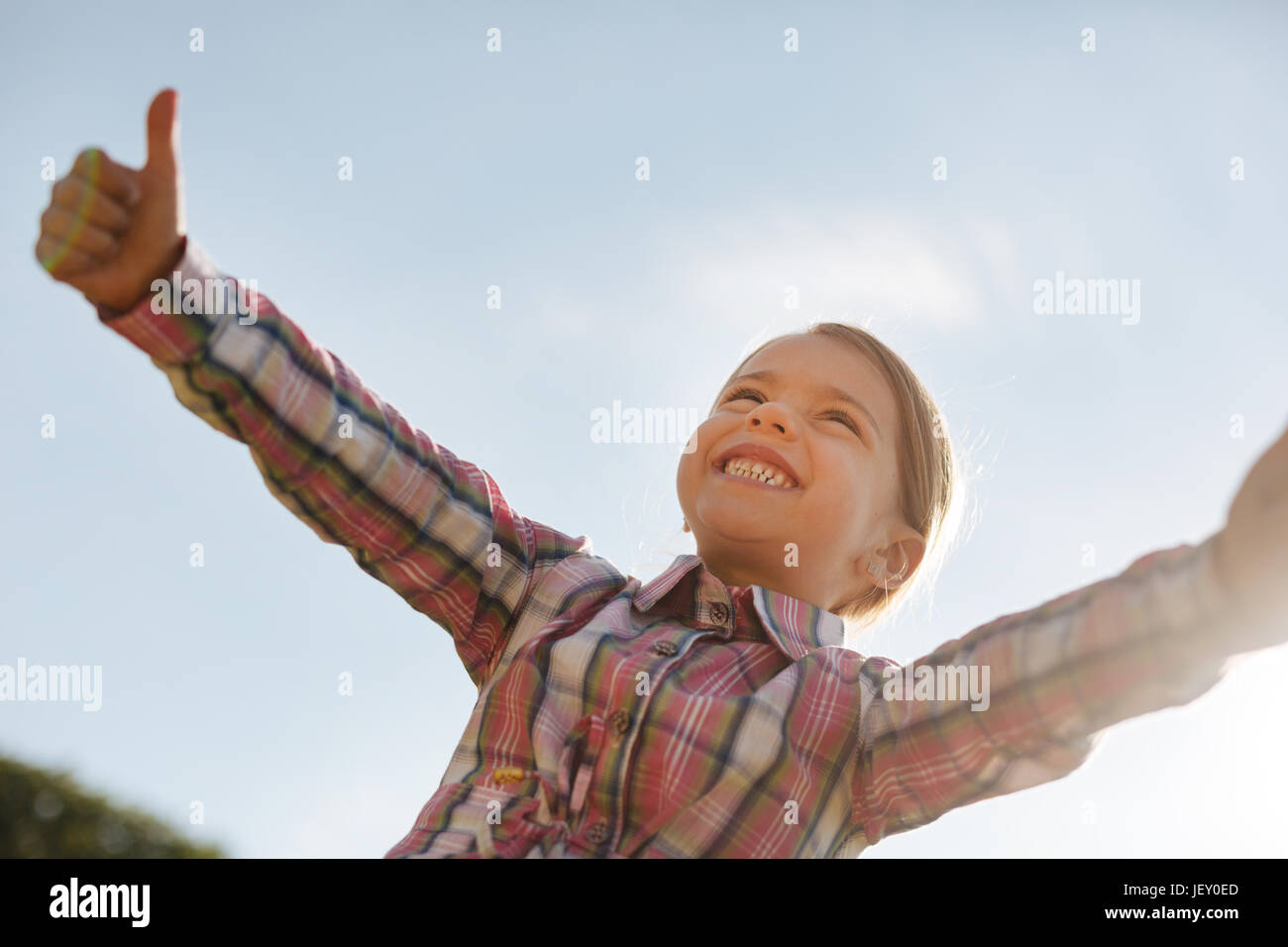 Low angle photo of delighted child that looking in the sky Stock Photo