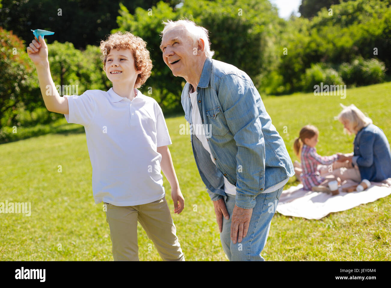 Positive teenager being glad while playing with paper plane Stock Photo