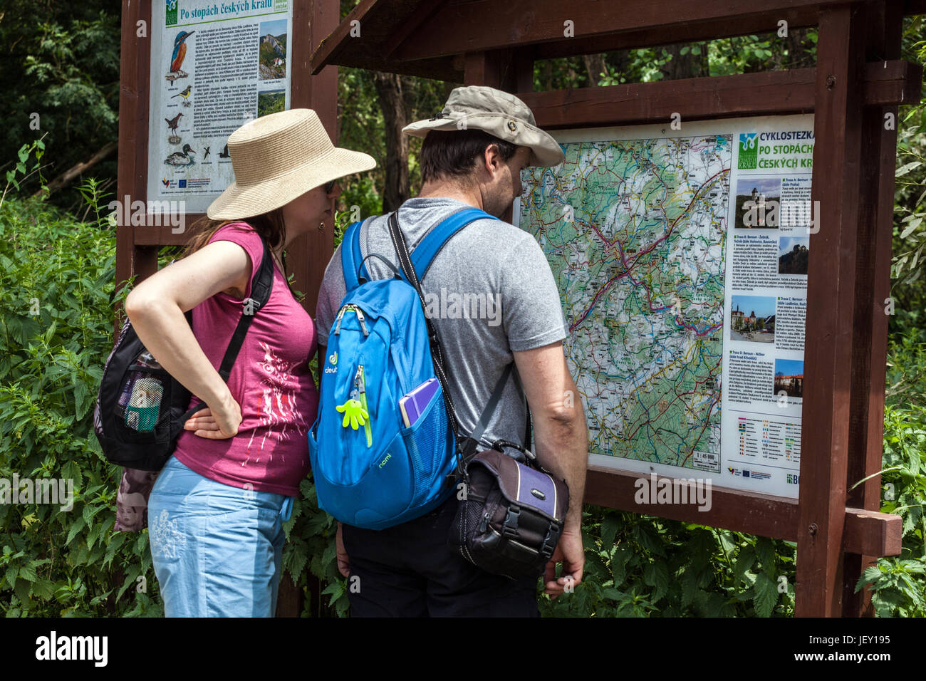 Middle-aged people hiking, a couple on a trip in the valley of the river Berounka, Looking at information board with a map Czech Republic hike Europe Stock Photo