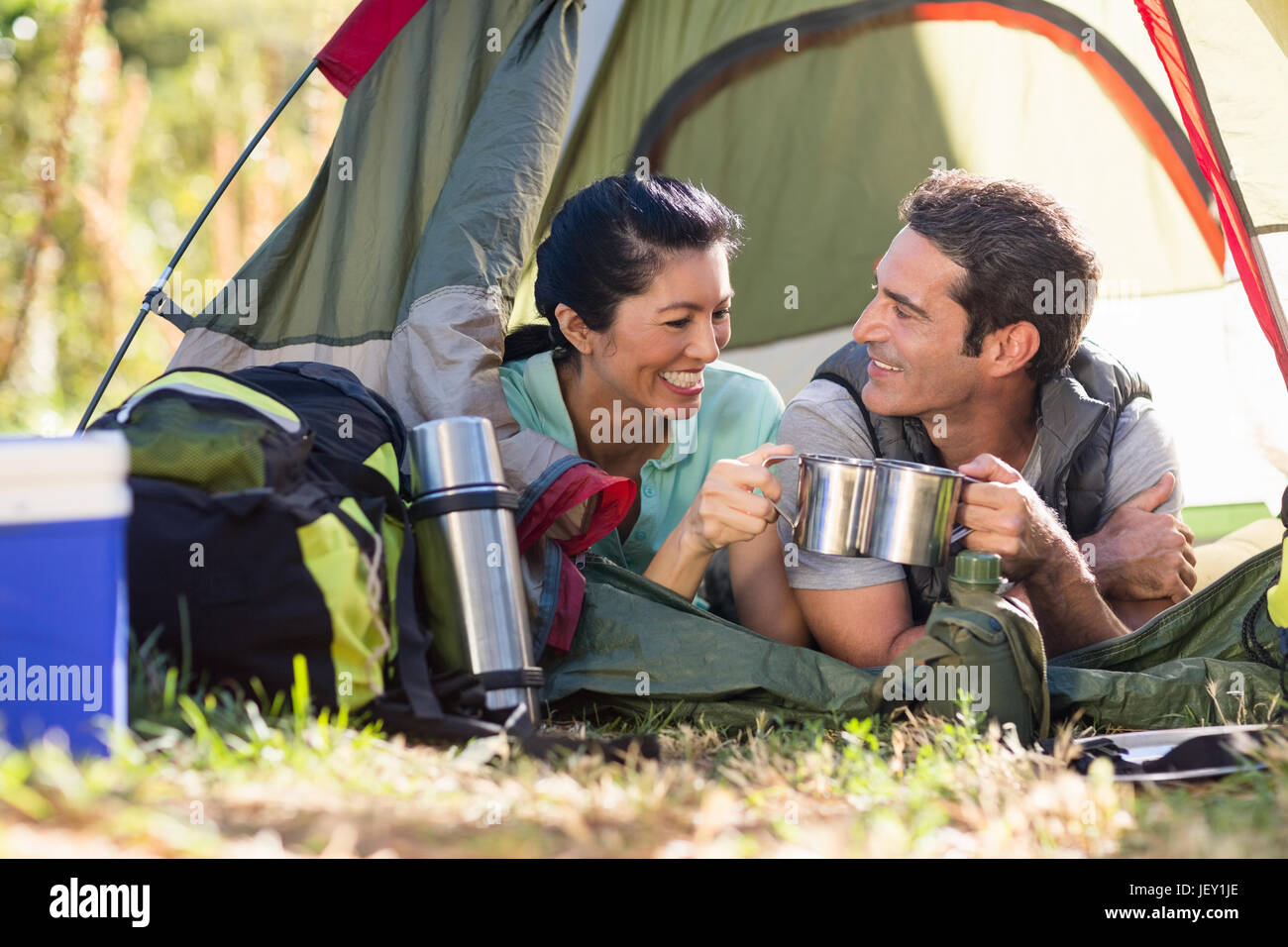 Couple laying and clinking cup Stock Photo - Alamy