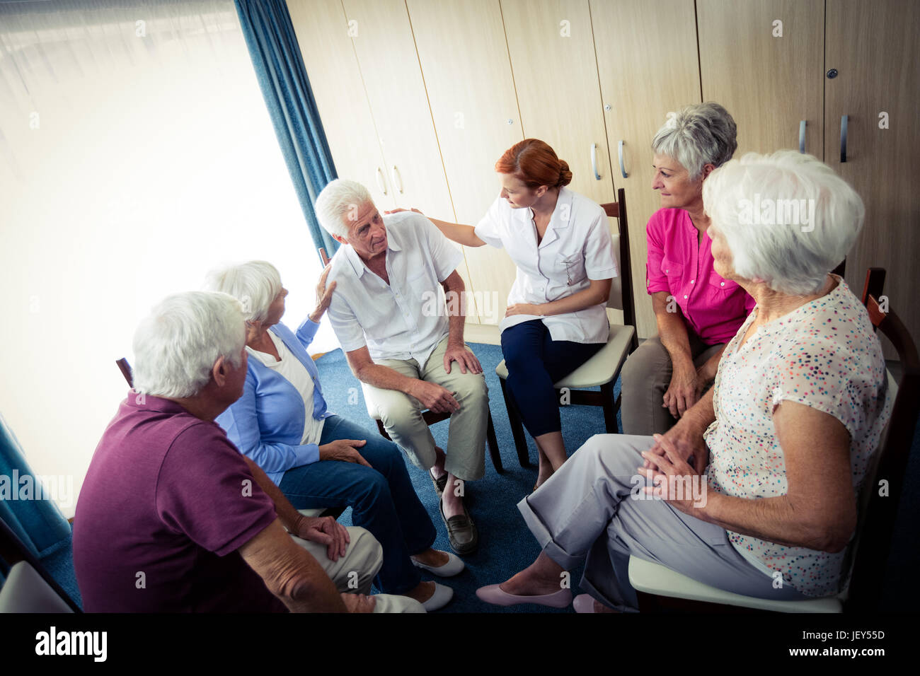 Seniors interacting with nurse Stock Photo