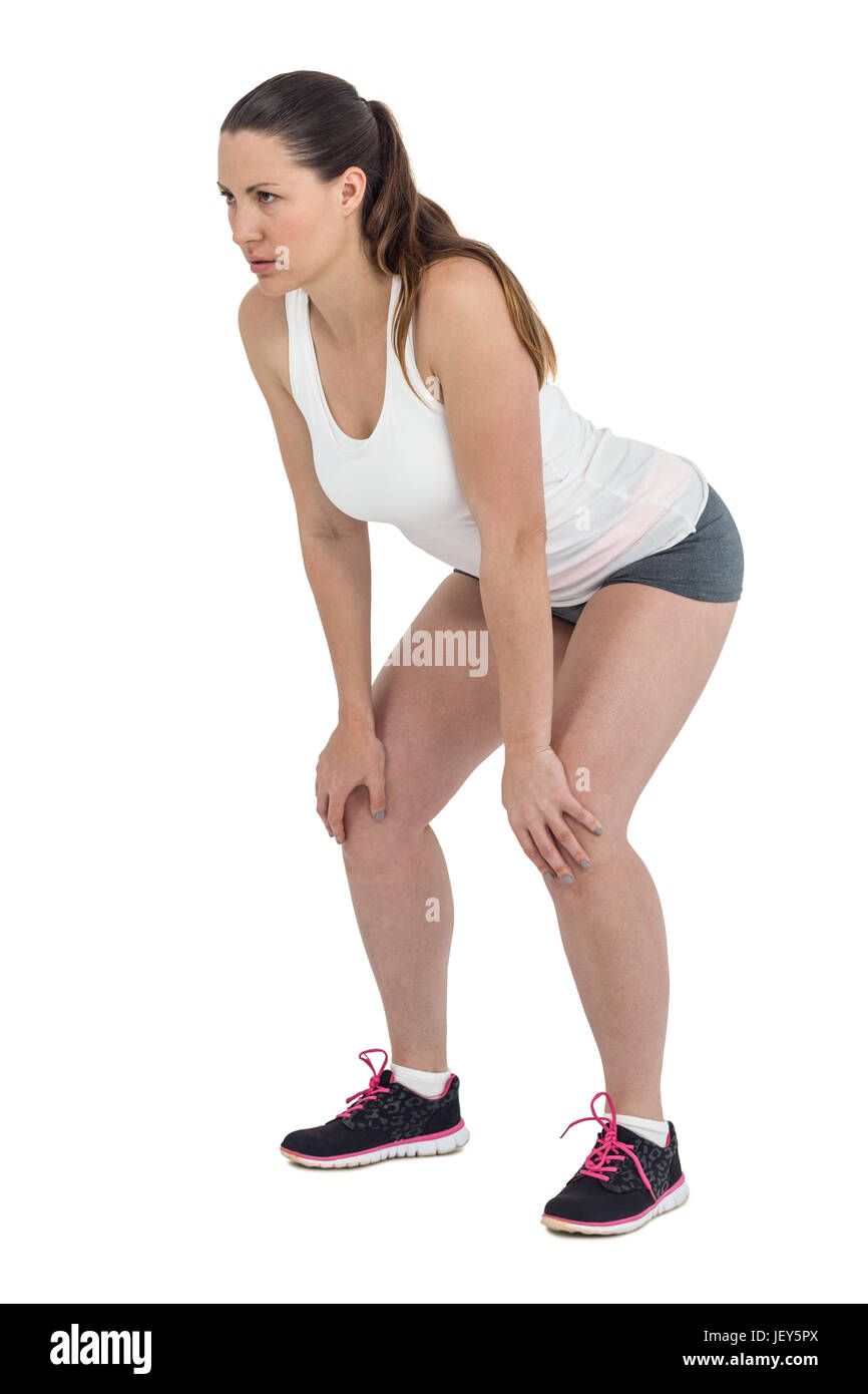 Tired athlete standing with hand on knee Stock Photo