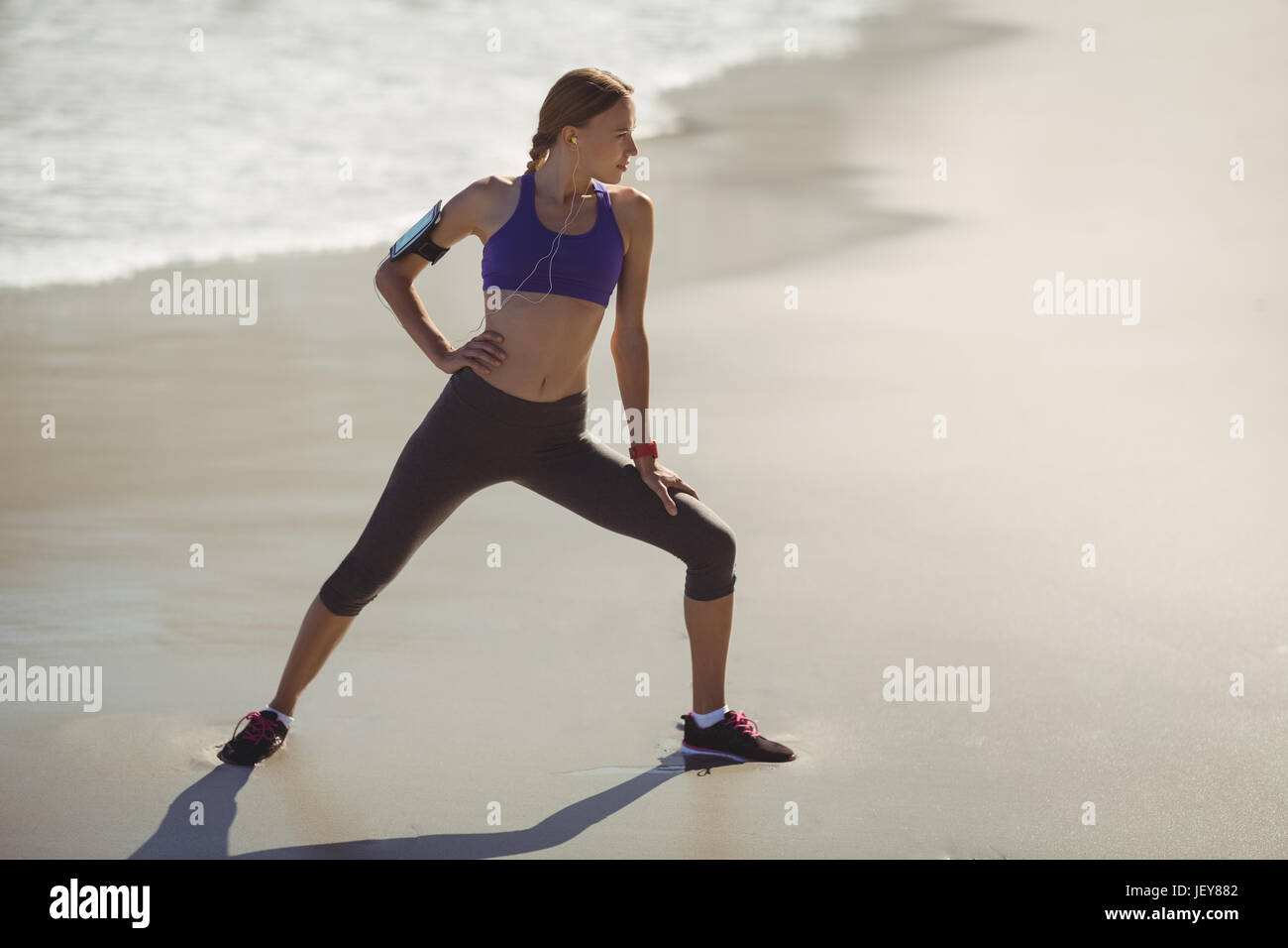 Fit woman warming up on beach Stock Photo