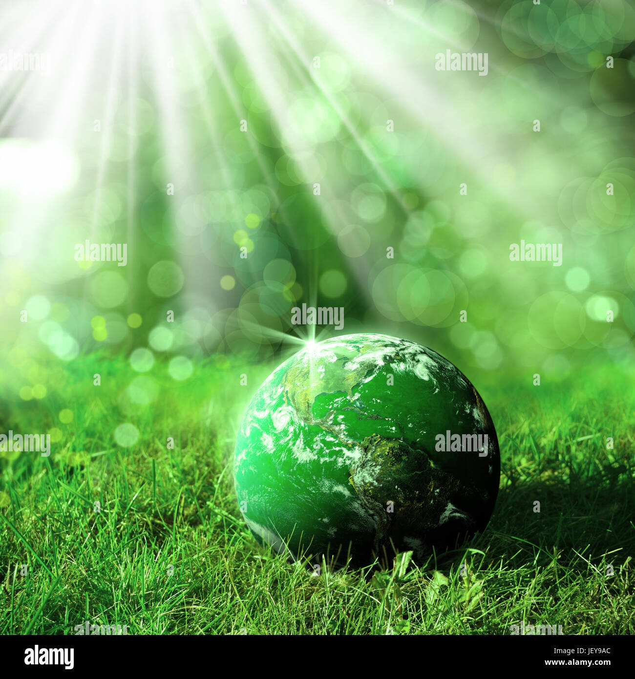 conceptual image of globe on green landscape and light. Furnished NASA image used for this image. Stock Photo