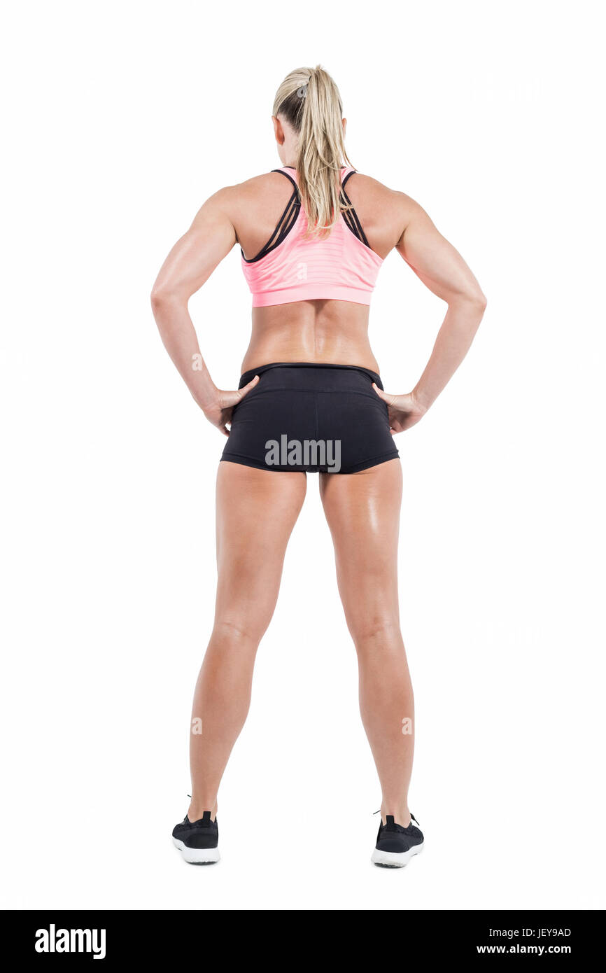Full body shot of slim sportive woman with her arms akimbo Stock
