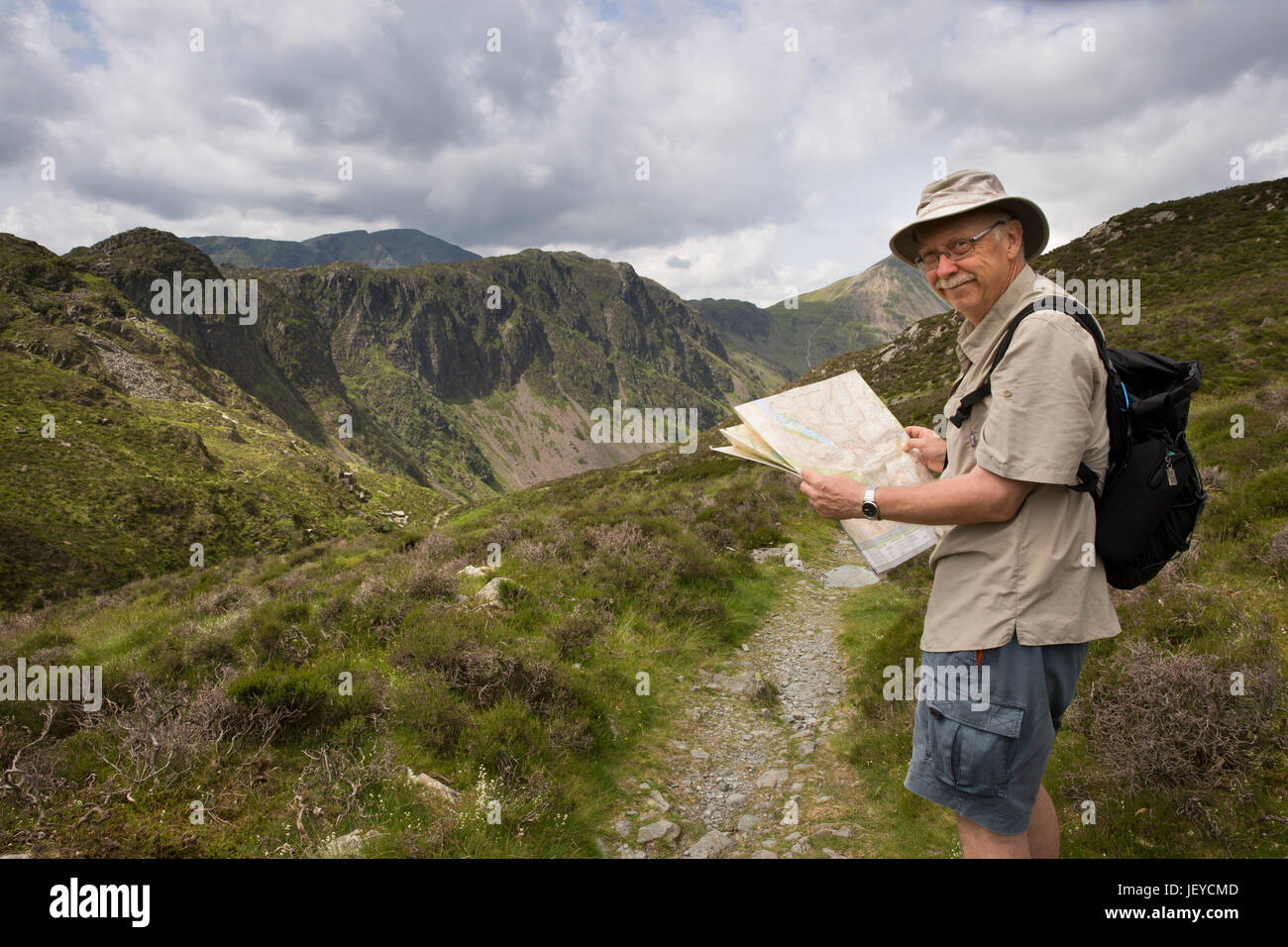 Cmb569UK, Cumbria, Fleetwith Pike, senior walker looking at map on path to Buttermere past High Stile, Stock Photo