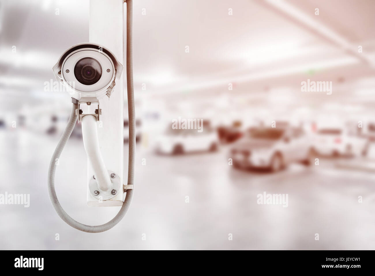 CCTV security camera with blurred car parking background Stock Photo