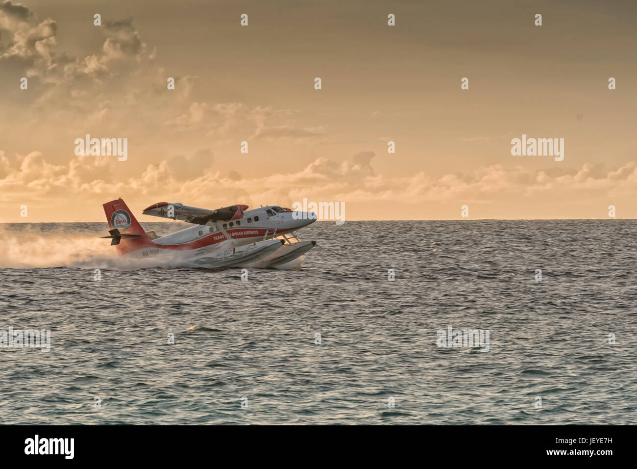 A Trans Maldivian Airways Twin Otter seaplane accelerates for takeoff from Meedhupparu island Maldives Stock Photo