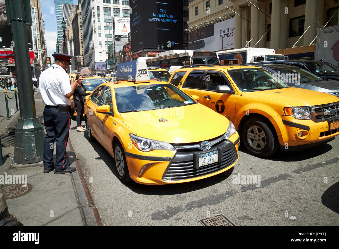 attendant at front of yellow cab rank New York City USA Stock Photo
