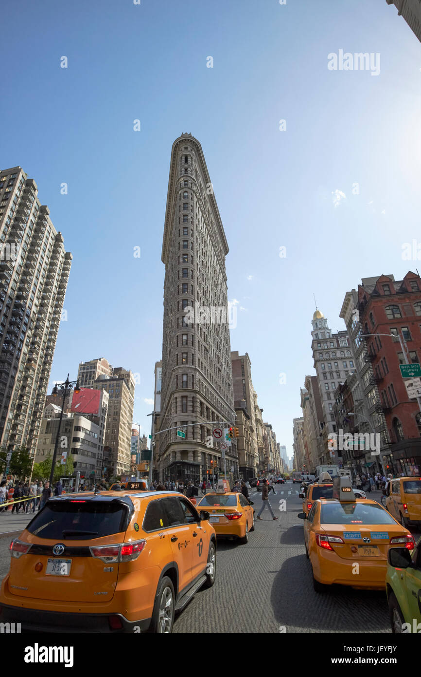 yellow cabs travelling fifth avenue passing the flatiron building district New York City USA Stock Photo