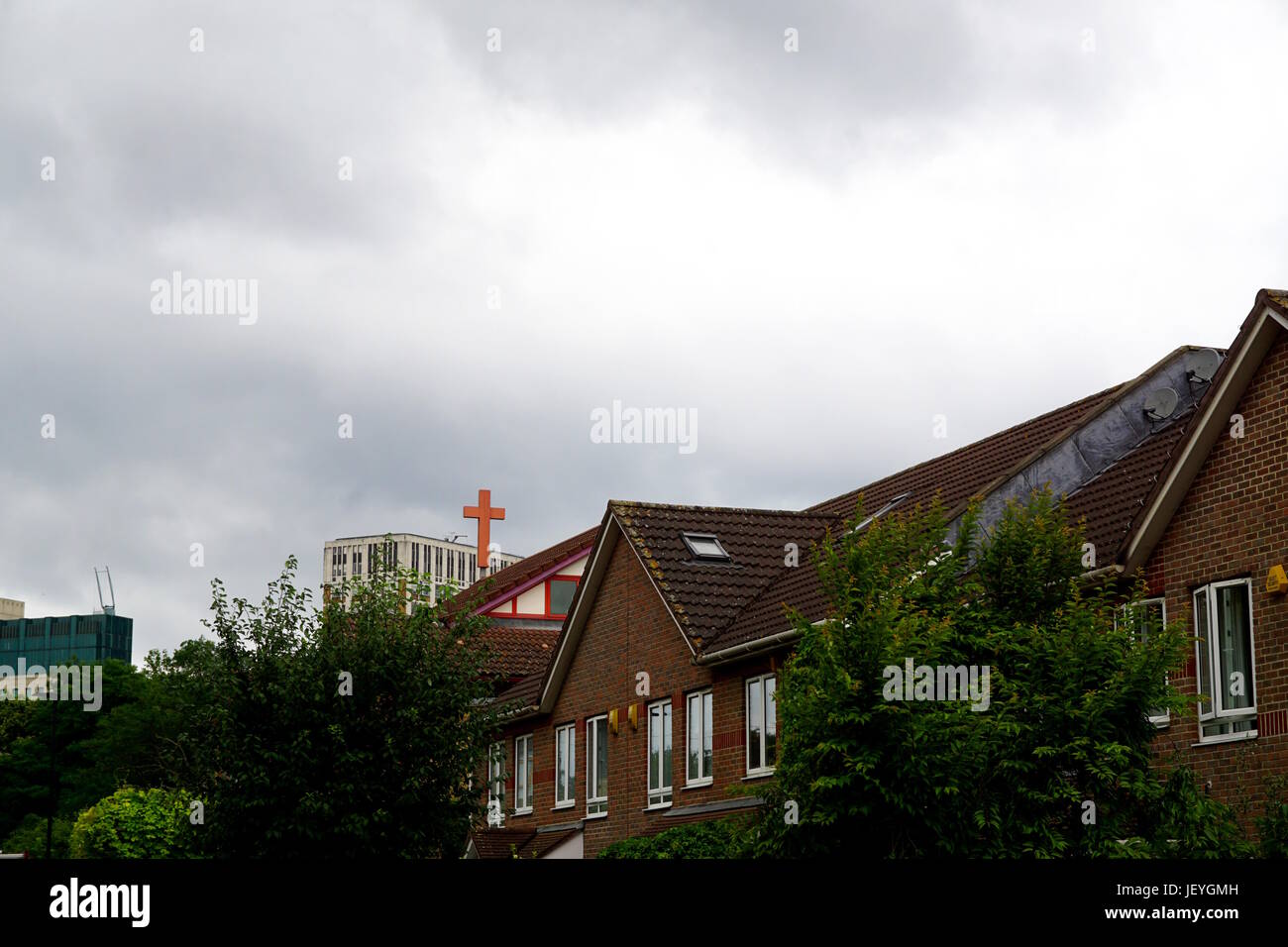 Church Cross above Rooftops Stock Photo