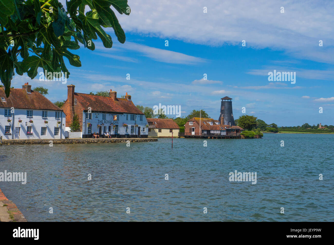 The Royal Oak pub and Langstone Mill at High TIde .Langston Harbour , Hampshire ,England.Langstone is a picturesque village that sits on the northern  Stock Photo