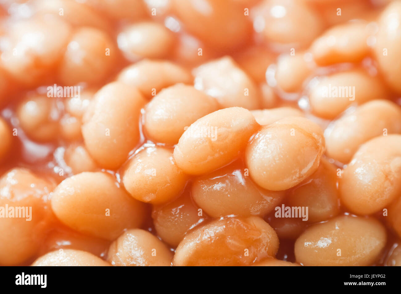 Cooked baked beans with tomato sauce in close-up.  Filling whole frame. Stock Photo