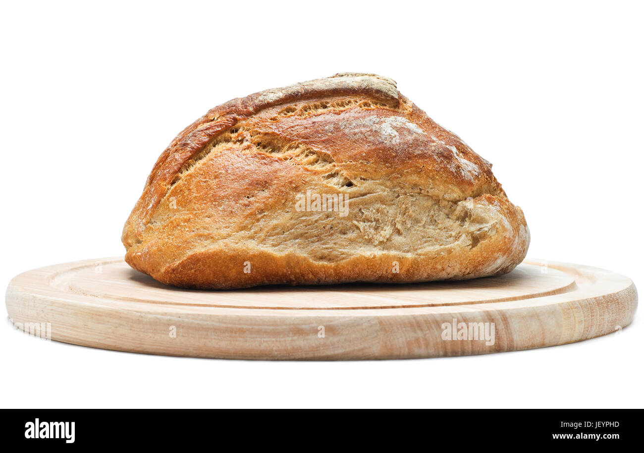 Side view (eye level) of a loaf of crusty wholemeal bread on a light wood chopping board.  Isolated on white background with shadows visible. Stock Photo
