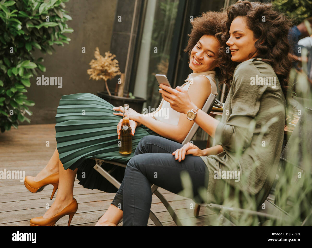 Two young women sit hi-res stock photography and images - Alamy