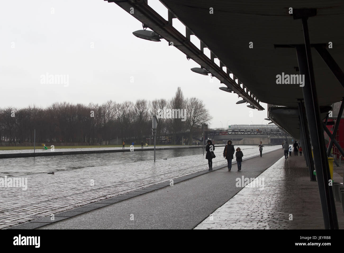 People walk by  'La Villette' river in 'Pont de Flandre' park in Paris. Stock Photo
