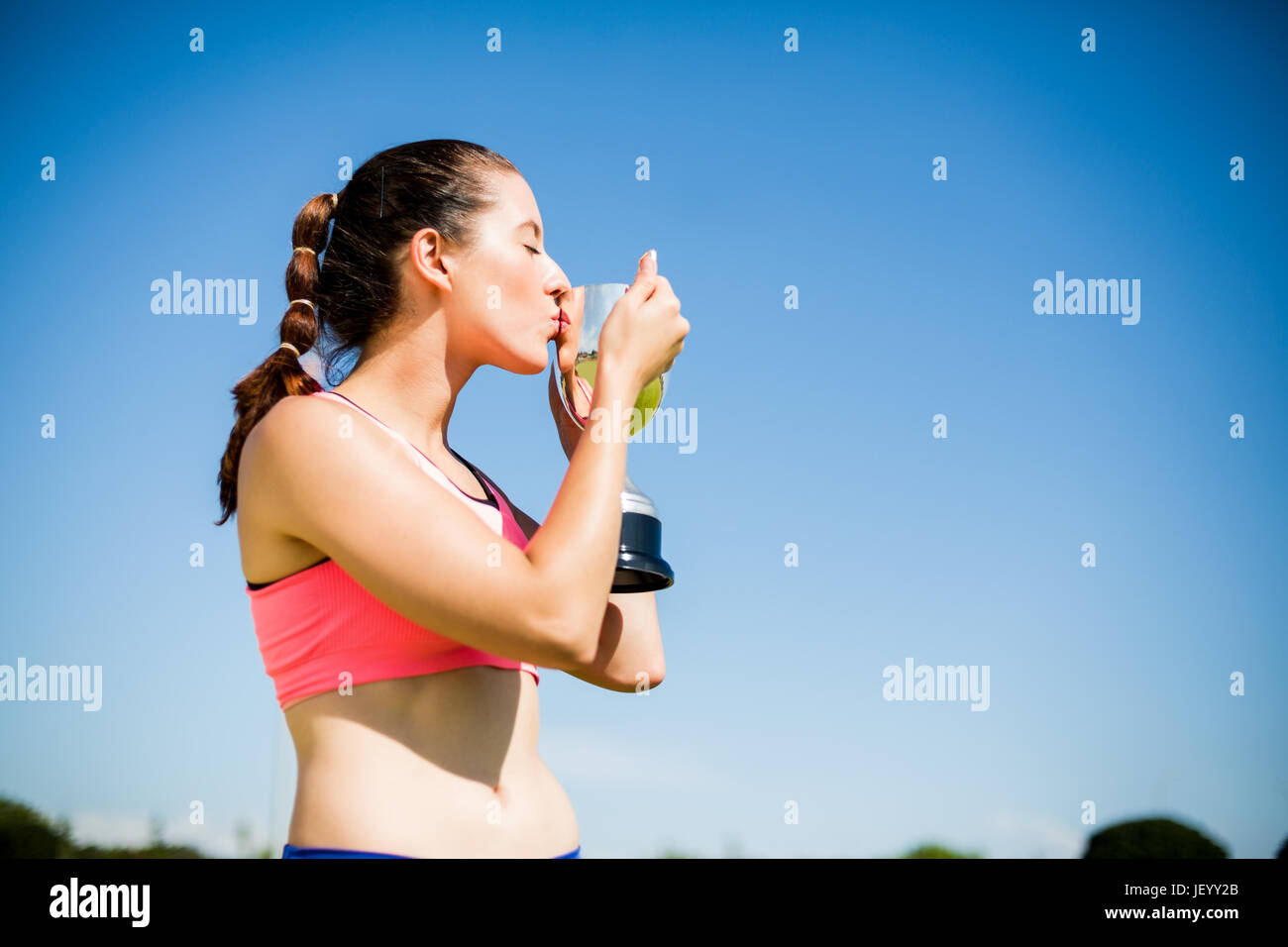 Female athlete kissing her trophy Stock Photo Alamy