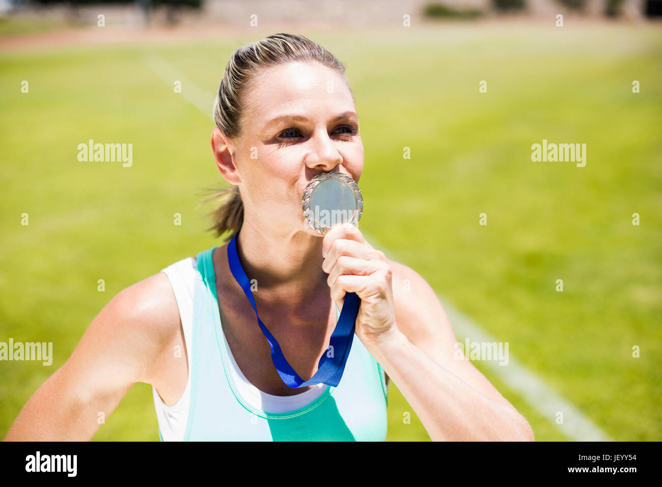 Female athlete kissing his gold medal Stock Photo Alamy