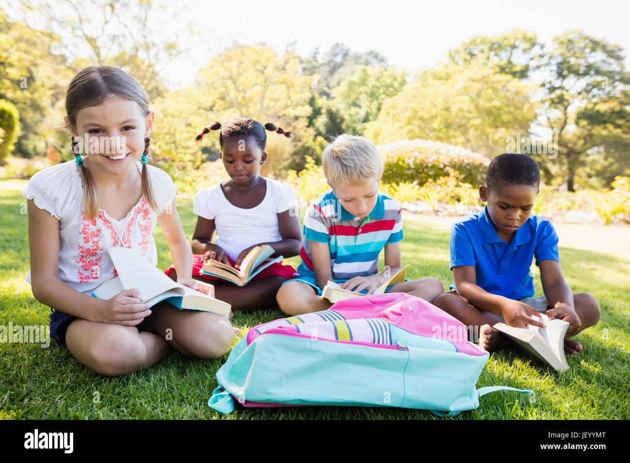 Kids reading books during a sunny day Stock Photo