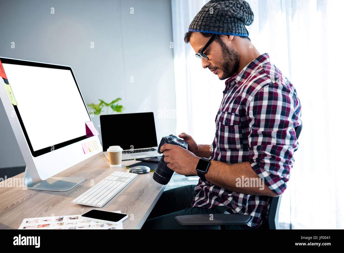 Side view of hipster working at desk Stock Photo