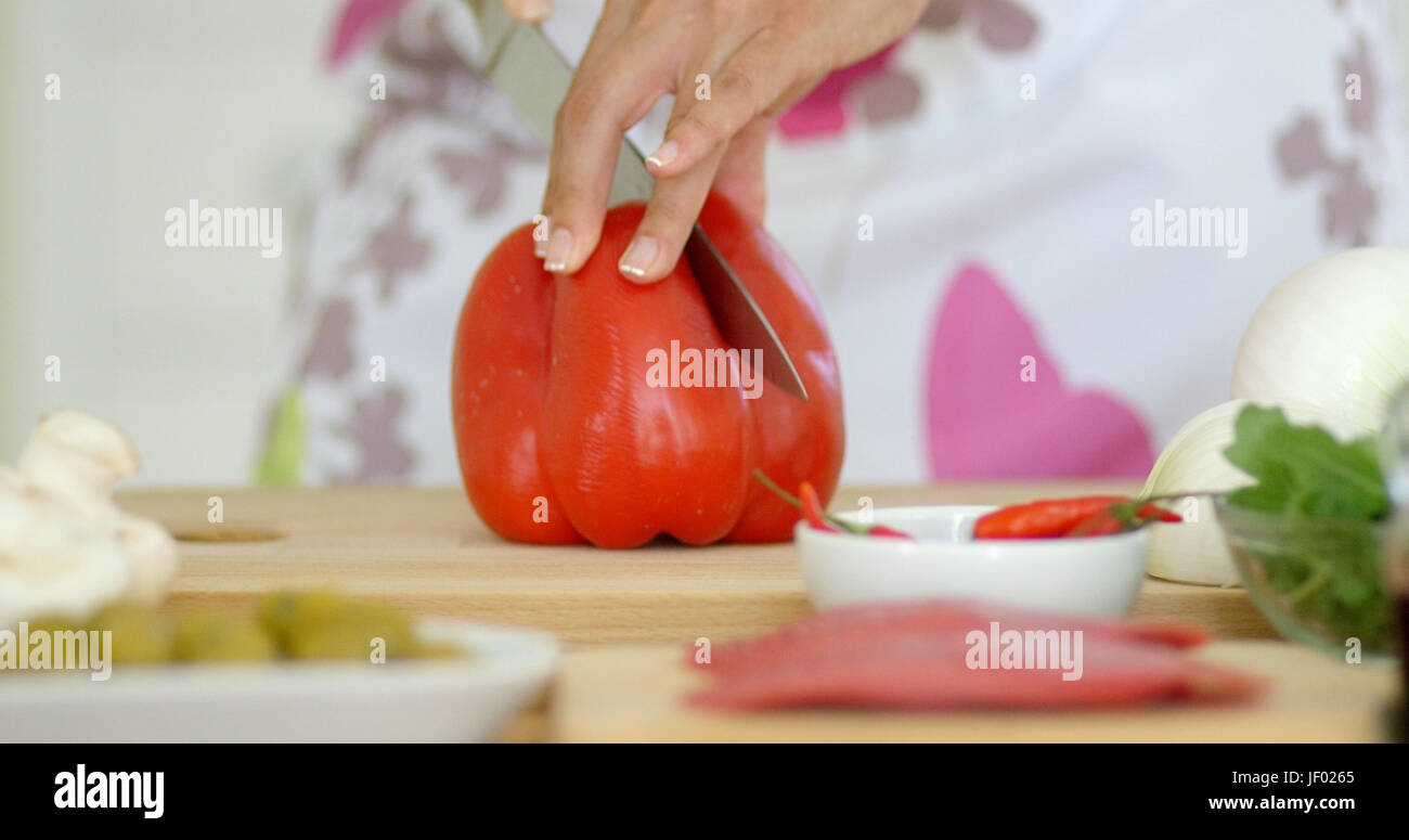 Housewife chopping a fresh red bell pepper Stock Photo - Alamy
